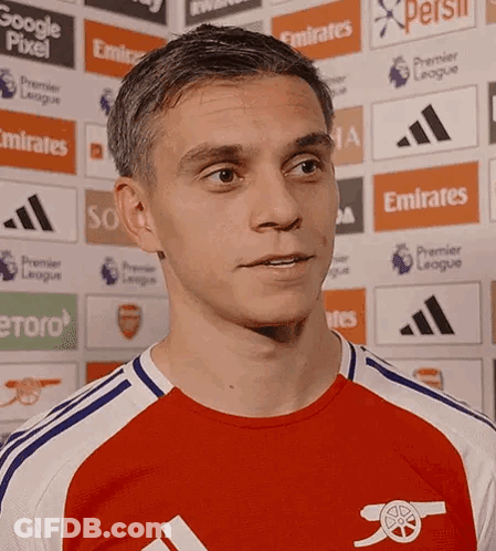 A Man Wearing A Red And White Jersey With An Arsenal Logo GIF
