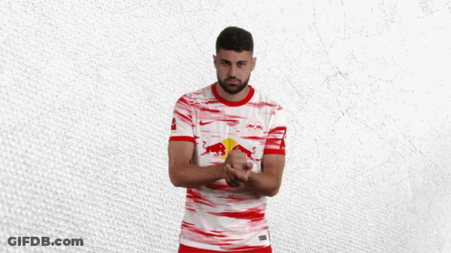 A Man Wearing A Red And White Shirt With A Bull On It GIF