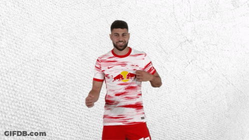 A Man Wearing A Red And White Shirt With A Red Bull On It GIF