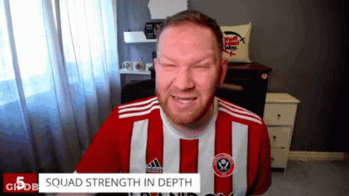 A Man Wearing A Red And White Striped Adidas Shirt Is Smiling GIF
