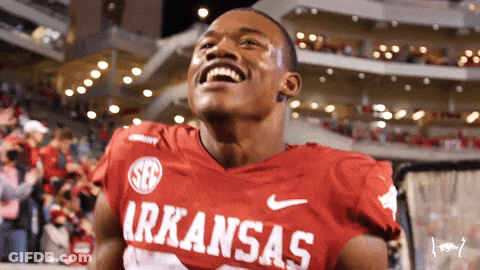 A Man Wearing A Red Arkansas Jersey Is Laughing GIF