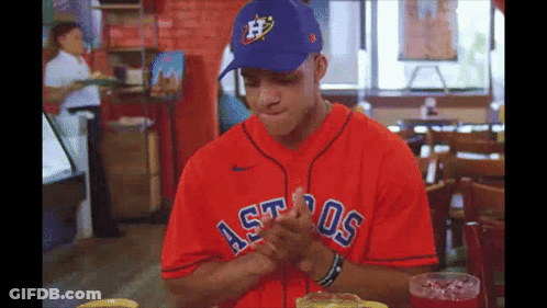 A Man Wearing A Red Astros Jersey And A Blue Hat GIF