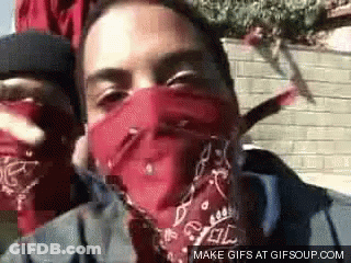 A Man Wearing A Red Bandana Covering His Face Is Smoking A Cigarette . GIF