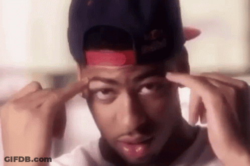 A Man Wearing A Red Bull Hat Is Holding His Hands To His Forehead . GIF