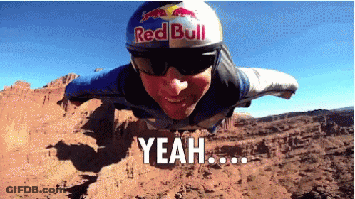 A Man Wearing A Red Bull Helmet And Sunglasses Is Flying Through The Air GIF