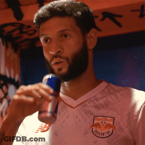 A Man Wearing A Red Bull Jersey Drinks From A Can GIF