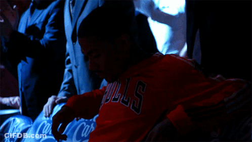 A Man Wearing A Red Bulls Shirt Sits In A Row Of Coca Cola Seats GIF