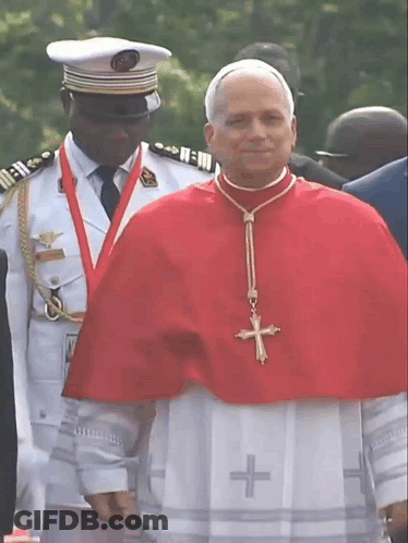 A Man Wearing A Red Cape With A Cross On It GIF