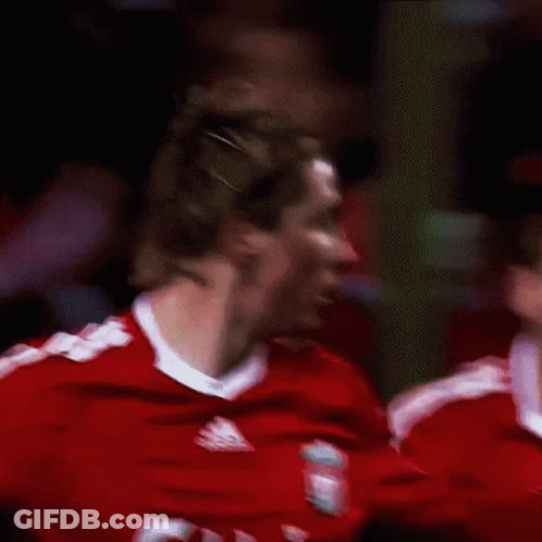 A Man Wearing A Red Carlsberg Jersey Looks To His Left GIF