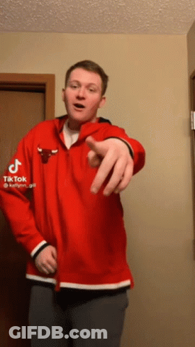 A Man Wearing A Red Chicago Bulls Jacket Points At The Camera GIF