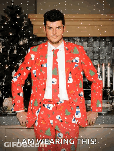 A Man Wearing A Red Christmas Suit With Snowmen And Trees On It GIF