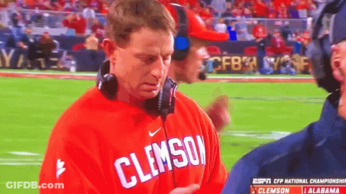 A Man Wearing A Red Clemson Shirt Stands On A Field GIF
