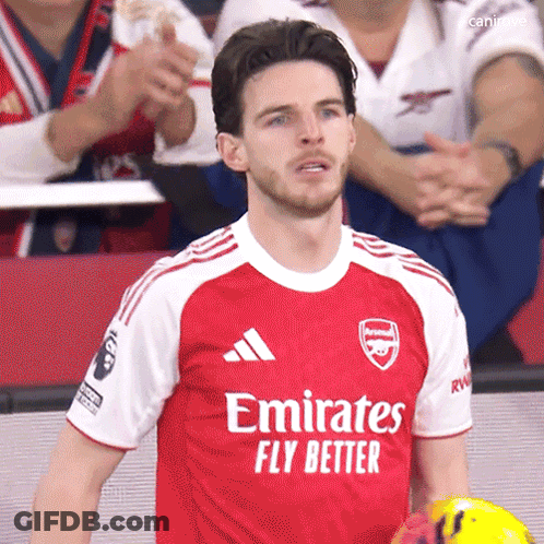 A Man Wearing A Red Emirates Fly Better Jersey Holds A Soccer Ball GIF