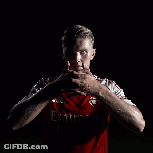 A Man Wearing A Red Emirates Jersey Holds His Hands To His Face GIF