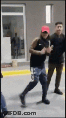 A Man Wearing A Red Hat And A Black Nike Shirt Is Running GIF