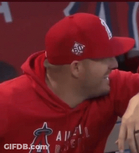 A Man Wearing A Red Hat And A Red Hoodie Is Smiling . GIF