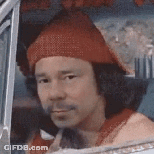 A Man Wearing A Red Hat And A Red Shirt Is Sitting In The Driver 'S Seat Of A Car . GIF
