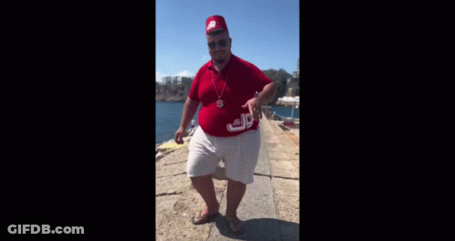 A Man Wearing A Red Hat And A Red Shirt Is Standing On A Pier . GIF