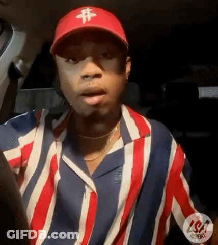 A Man Wearing A Red Hat And A Striped Shirt Is Sitting In A Car . GIF