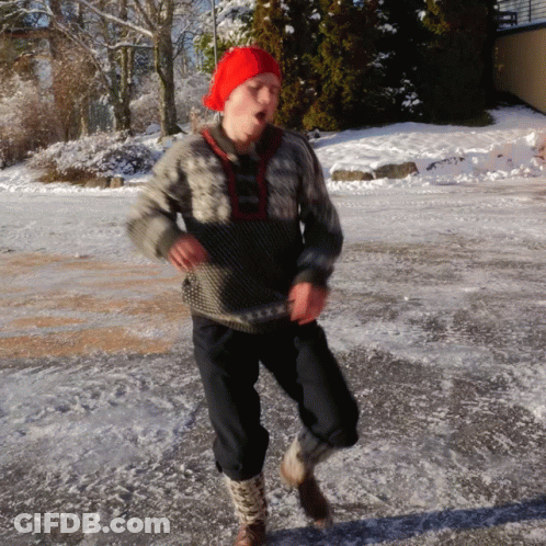 A Man Wearing A Red Hat And A Sweater Is Running On The Ice GIF