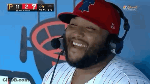 A Man Wearing A Red Hat And Headphones Is Laughing GIF