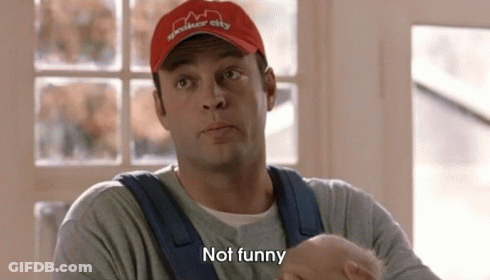 A Man Wearing A Red Hat And Overalls Is Holding A Baby And Saying `` Not Funny '' . GIF