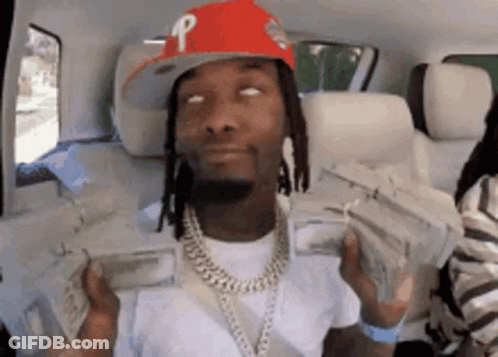A Man Wearing A Red Hat Is Holding A Bunch Of Money In His Hands . GIF