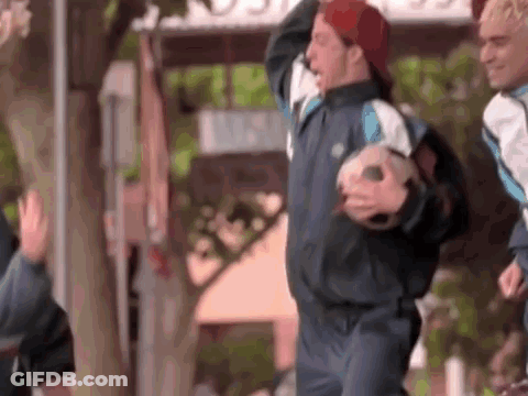 A Man Wearing A Red Hat Is Holding A Soccer Ball In His Hands . GIF