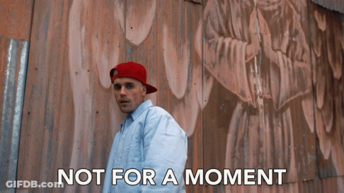 A Man Wearing A Red Hat Stands In Front Of A Wall With The Words Not For A Moment Written Below Him GIF