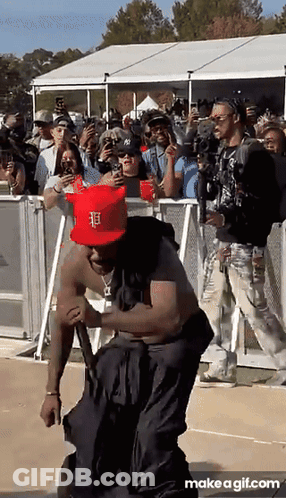 A Man Wearing A Red Hat With The Letter F On It Is Dancing In Front Of A Crowd GIF