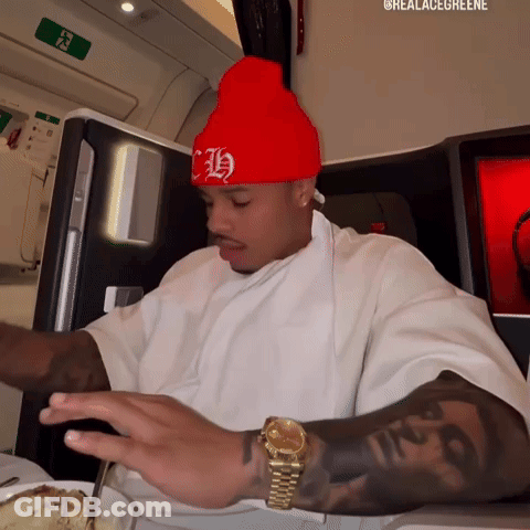 Man In Red Hat With H Sitting At Table GIF