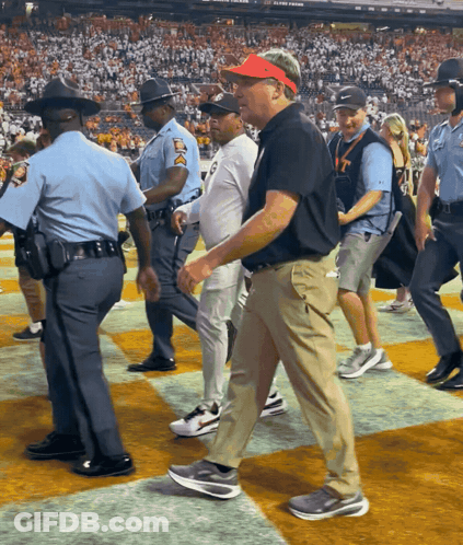 A Man Wearing A Red Hat With The Number 17 On It Walks On A Checkered Field GIF