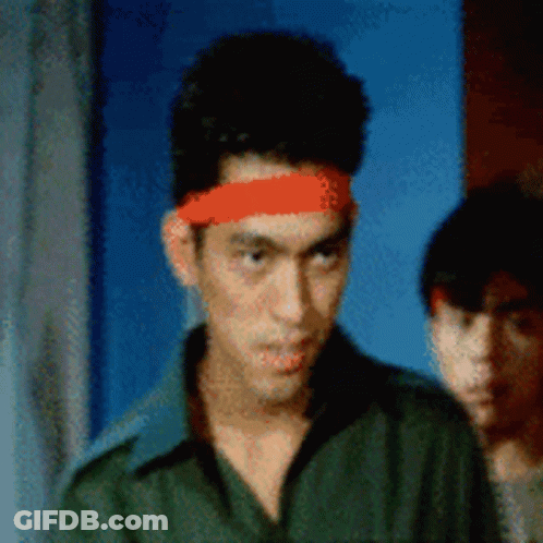 A Man Wearing A Red Headband Is Looking At The Camera GIF