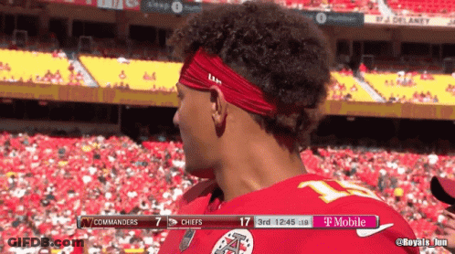 A Man Wearing A Red Headband Stands In Front Of A T Mobile Banner GIF