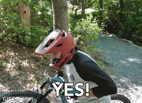 A Man Wearing A Red Helmet Is Riding A Bike And Says " Yes " In White Letters GIF