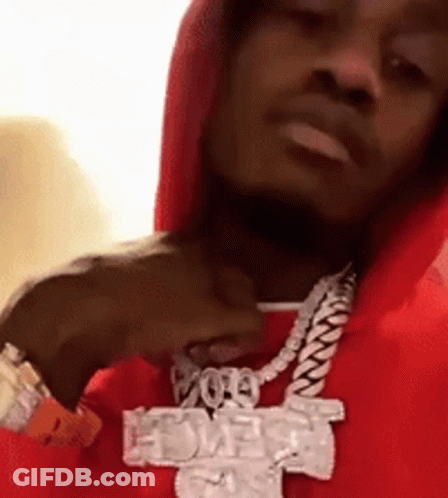 A Man Wearing A Red Hoodie And A Necklace With A Cross On It GIF