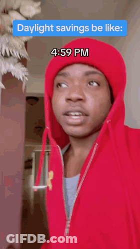 A Man Wearing A Red Hoodie And A Red Hat Says Daylight Savings Be Like At 4:59 Pm GIF