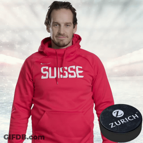 A Man Wearing A Red Hoodie That Says Suisse Next To A Zurich Puck GIF