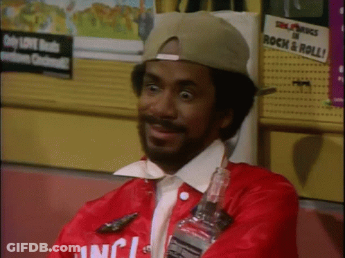 A Man Wearing A Red Jacket That Says ' Inc ' On It Is Holding A Bottle GIF