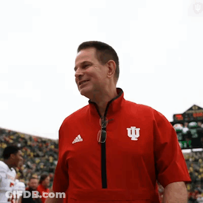 A Man Wearing A Red Jacket With The Letter I On The Front GIF