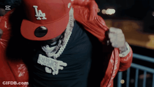 A Man Wearing A Red La Hat And A Black Shirt GIF