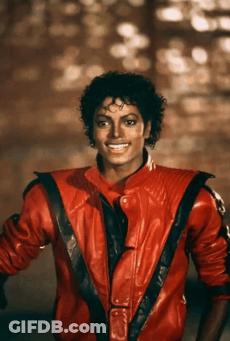 A Man Wearing A Red Leather Jacket Is Smiling GIF