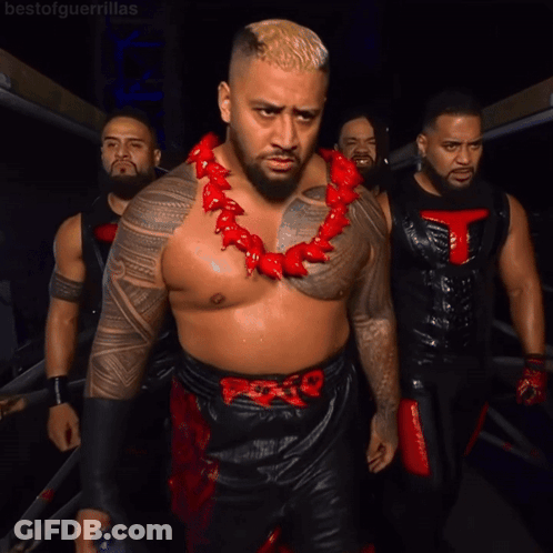 A Man Wearing A Red Necklace With A T On It GIF