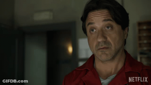 A Man Wearing A Red Netflix Shirt Looks At The Camera GIF