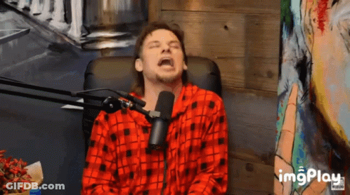 A Man Wearing A Red Plaid Shirt Is Sitting In Front Of A Microphone With His Eyes Closed And The Word Imgplay Below Him GIF