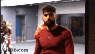 A Man Wearing A Red Puma Shirt Stands In A Gym GIF