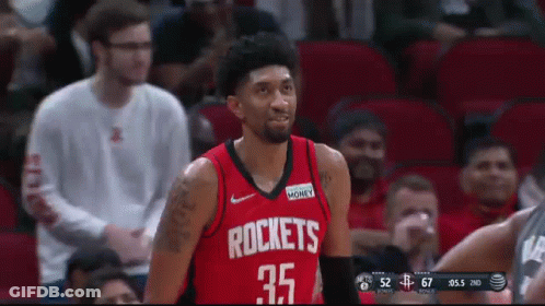 A Man Wearing A Red Rockets Jersey Stands In Front Of A Crowd GIF