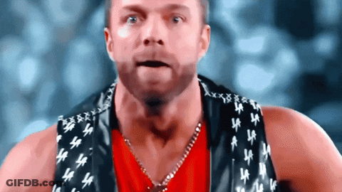 A Man Wearing A Red Shirt And A Black Vest With La Letters On It GIF