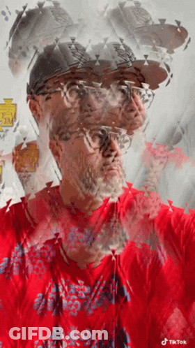 A Man Wearing A Red Shirt And A Hat Has A Tiktok Logo On His Shirt GIF