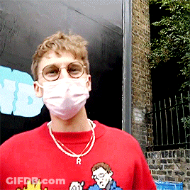 A Man Wearing A Red Shirt And A Mask With The Letter R On His Neck GIF